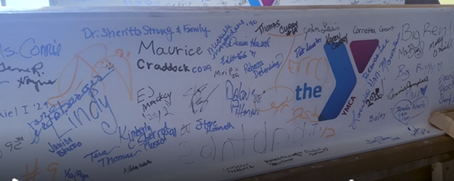 North Omaha residents and Omaha North students sign steel beams for the future Gene R. Haynes Stadium and Butler-Gast YMCA